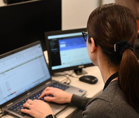 An RCMP analyst works on her laptop researching men seeking sexual services from undercover officers. Photo: B.C. RCMP